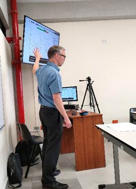 A person standing in front of a screen

Description automatically generated with medium confidence